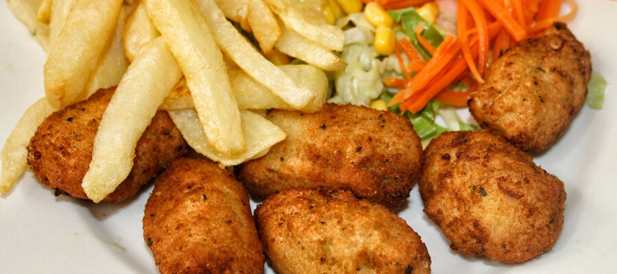 Croquetas acompañadas de papas y ensalada